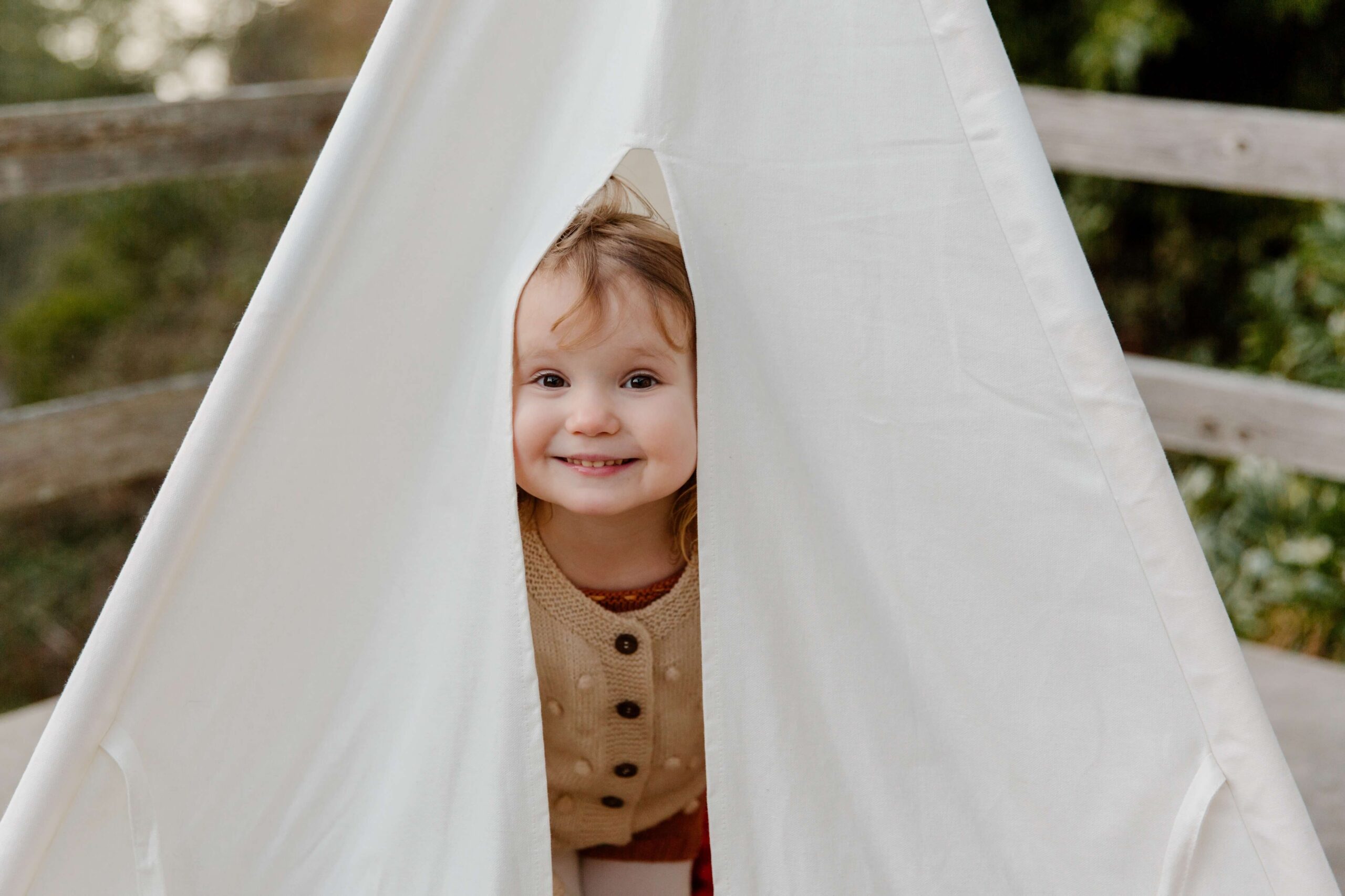 Happy child peeking from tent