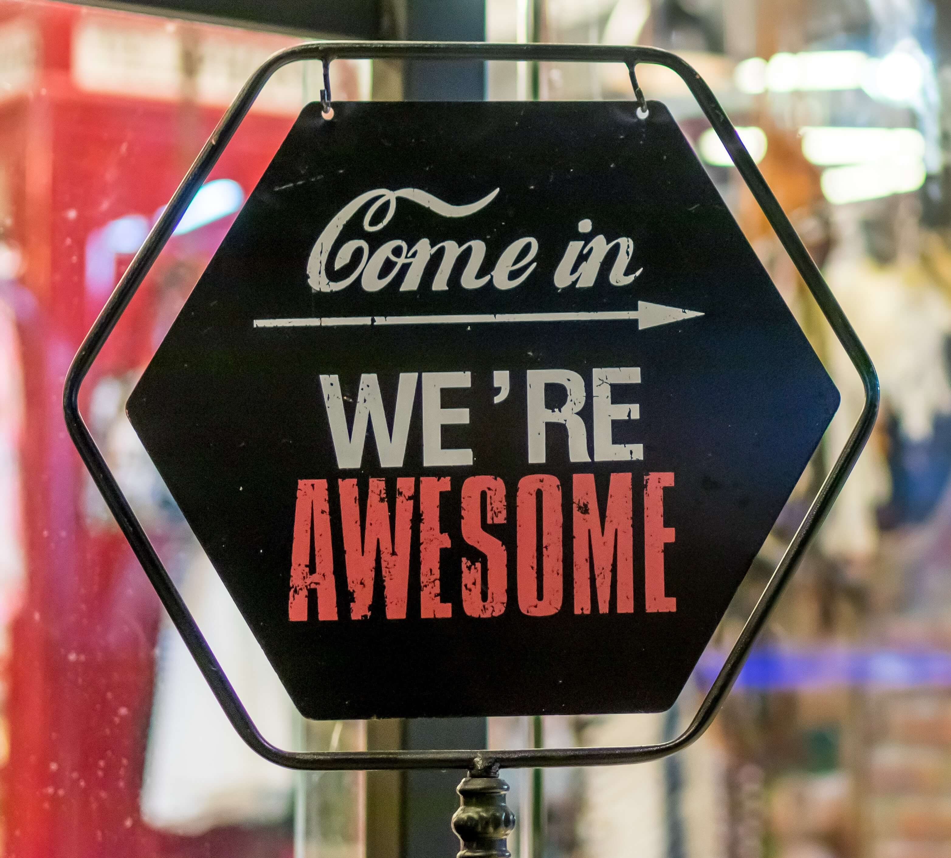 Sign on shop door saying Come in we're awesome